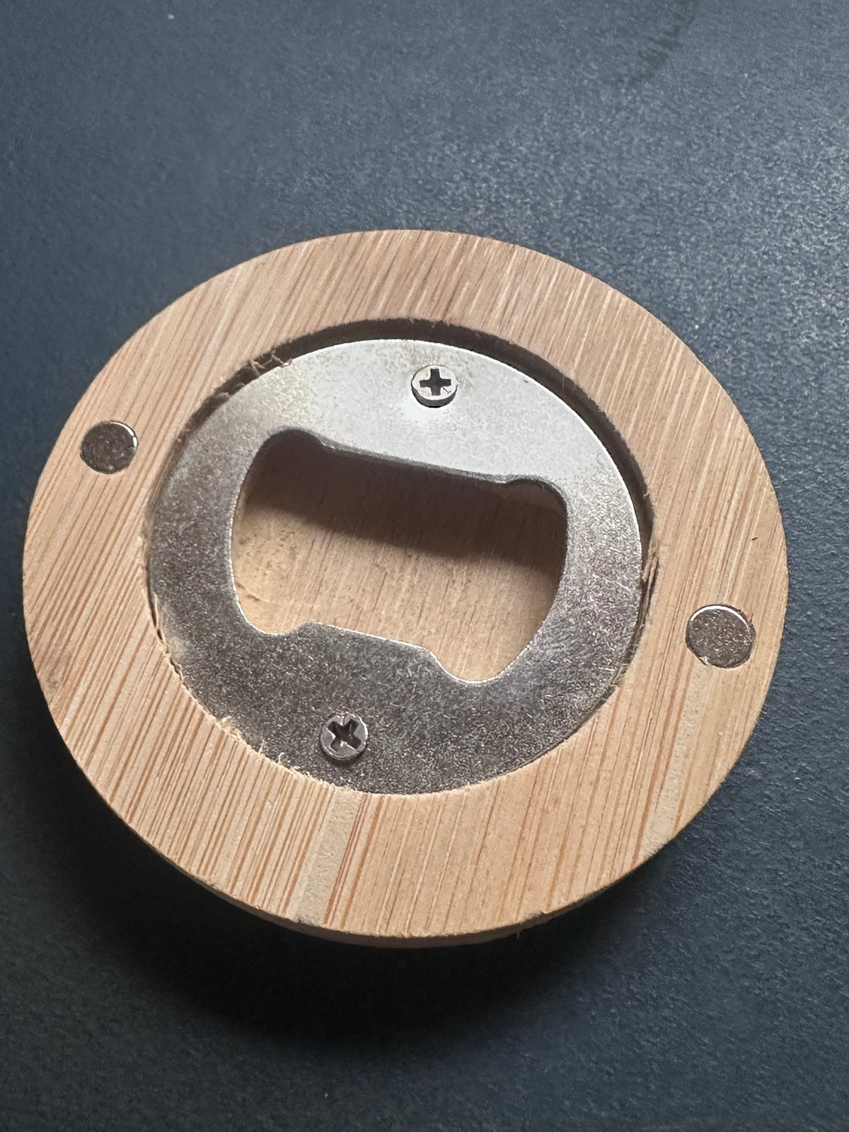 Back of the bamboo bottle opener showing the steel bottle opener insert and two magnets