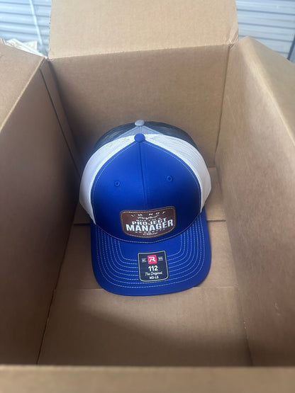 Royal blue Richardson 112 trucker hat with a custom laser-engraved leather patch